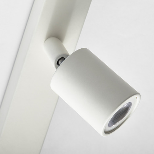 Primer plano de un foco de luz de pared moderno y minimalista, en forma de cilindro con ángulo ajustable.
