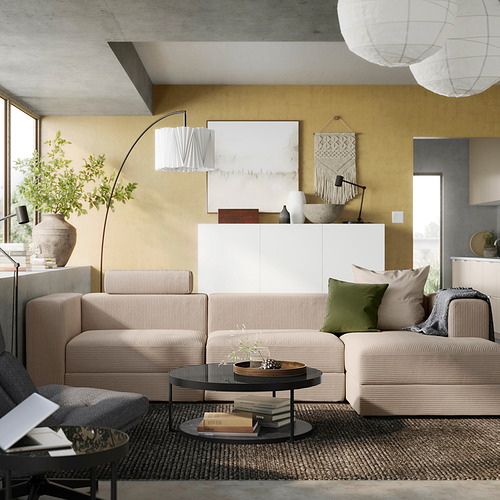 Sala de estar moderna con sofá JÄTTEBO beige, pared amarilla, alfombra gris y luces colgantes.