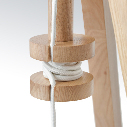 Lámpara de madera con altura ajustable, cable cuidadosamente enrollado alrededor de la base.