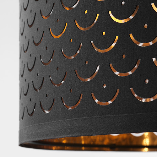 Pantalla negra con intrincados y brillantes recortes semicirculares. La luz dorada brilla desde el interior, creando un patrón decorativo.