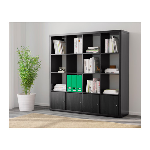 Estantería KALLAX negra con almacenaje, libros, decoración y planta.