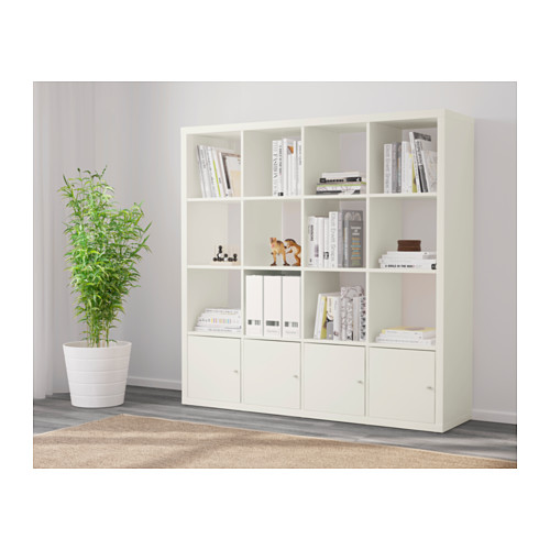 Estantería KALLAX blanca, que exhibe libros, artículos de decoración, con armarios cerrados debajo.