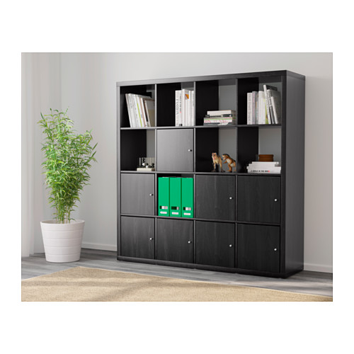 Mueble de almacenaje negro con mezcla de estanterías abiertas y armarios cerrados. Sostiene libros, decoración y esconde archivos.
