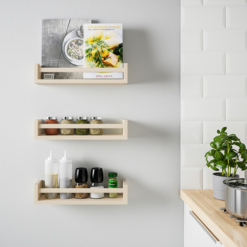 Los estantes de madera contienen libros de cocina, especias, condimentos y una planta.