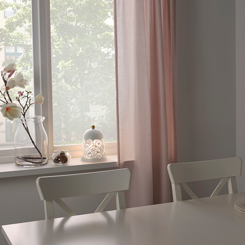 Ventana con cortinas transparentes, lámpara, jarrón de flores, silla gris.
