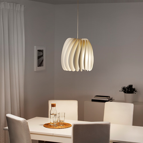 Comedor moderno con lámpara SKYMNINGEN sobre mesa y sillas blancas, paredes grises.