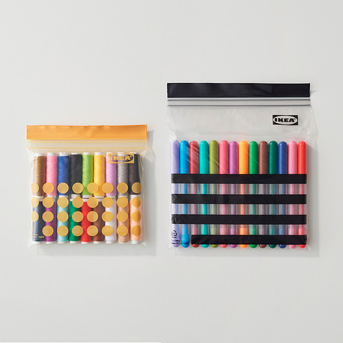 Dos bolsas de plástico transparentes resellables de IKEA, una con hilos de colores y la otra con marcadores, que muestran las capacidades de organización y almacenamiento.