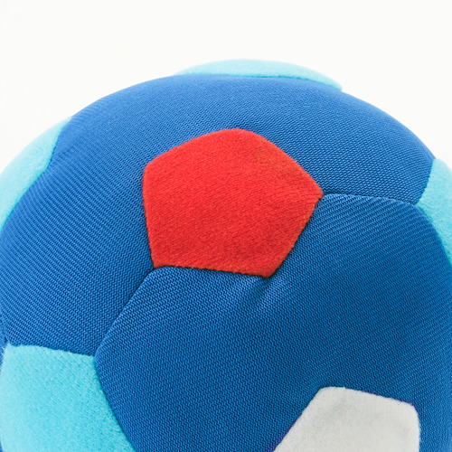 Pelota suave y multicolor en primer plano, principalmente azul, rojo y azul claro con logotipo blanco, la superficie se ve duradera y segura para los niños.
