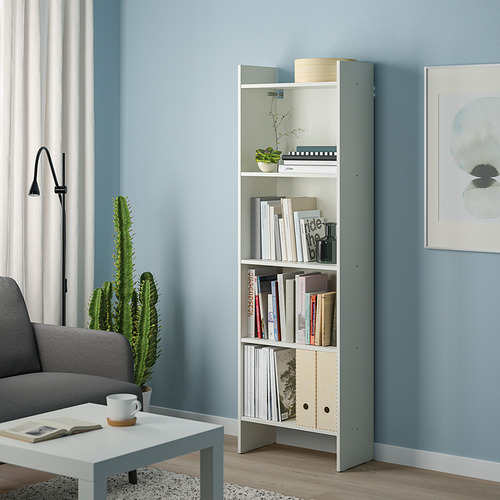 Librería BAGGEBO blanca con detalles en azul, cinco estantes cerca del sofá gris.