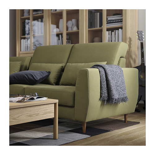 Sala de estar moderna con sofá SLATORP verde, mesa de centro de madera y estanterías con libros y decoración.