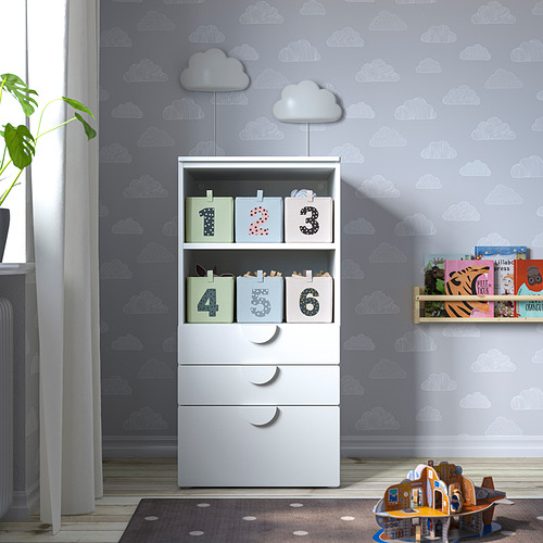 Habitación infantil con paredes de nubes, mueble de almacenaje, alfombra, estantería, juguetes, cortina, radiador, planta.