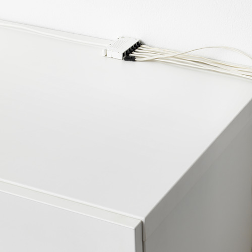 Caja eléctrica blanca montada en la pared, conectada a seis cables blancos, controlando hasta 6 fuentes de luz con un interruptor.