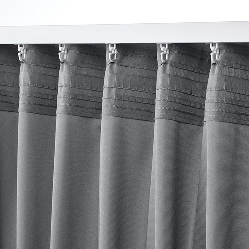 Primer plano de las cortinas SANDSVINGEL. Tela gris texturizada con cinta de cabecera y ganchos, que cuelga uniformemente.