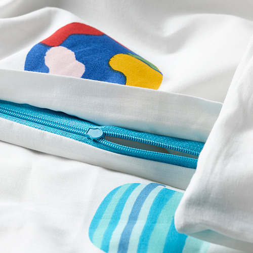 Primer plano de una funda nórdica blanca con coloridos diseños de planetas, con cremallera azul. Forma parte de la colección AFTONSPARV.