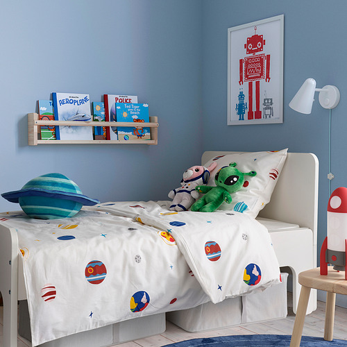 Habitación infantil con edredón AFTONSPARV, planetas, estrellas, pared azul, estantería, póster de robot rojo, almohada de planeta azul, juguete verde, lámpara de cohete roja.