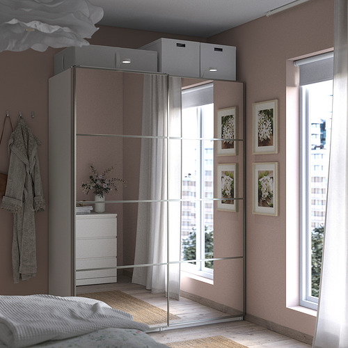 Dormitorio moderno con armario PAX con espejo, gran ventana y cama acogedora.