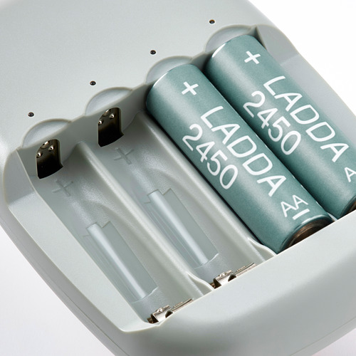 Baterías recargables en cargador de calidad. Cuatro baterías verdes etiquetadas como ladda 2450 en ranuras.