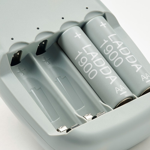 Cuatro baterías recargables grises etiquetadas como LADDA 1900 en un cargador gris.