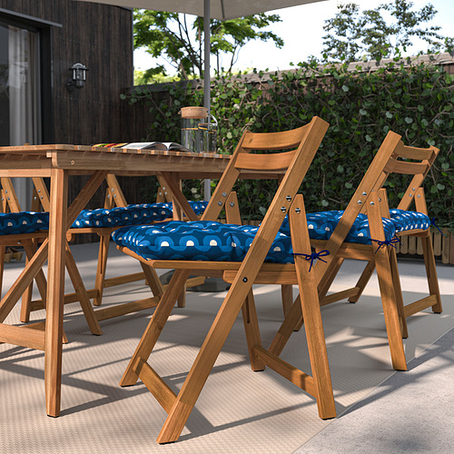 Sillas de patio plegables de madera con cojines geométricos azules y lazos para una colocación segura.