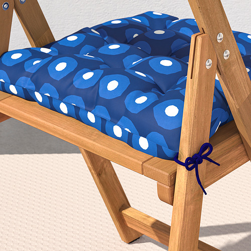 Una silla plegable de madera con un cojín azul estampado asegurado por lazos.