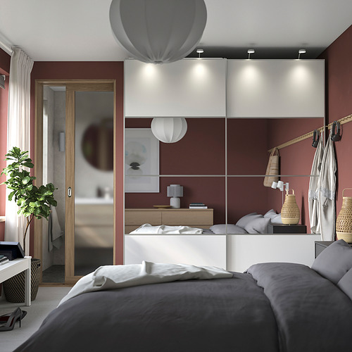 Dormitorio moderno con cama gris, armario PAX blanco, paredes rojas y lámparas colgantes.