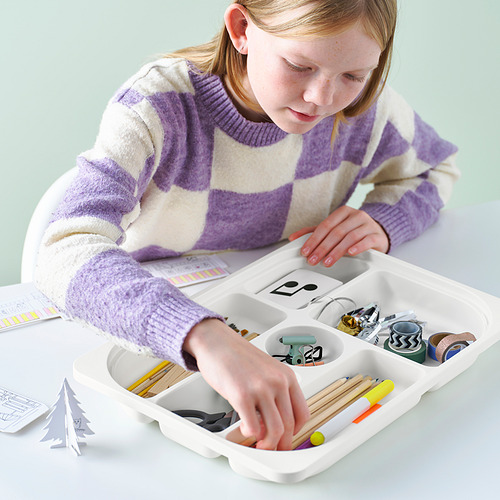 Niña organizando materiales de manualidades en bandeja TROFAST.