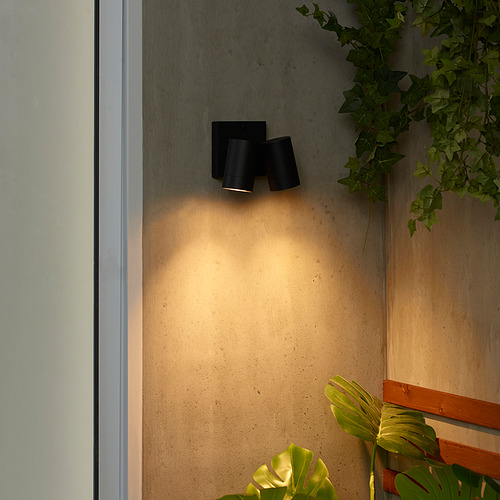 Lámpara de pared negra con 2 bombillas, plantas verdes, agrega luz acogedora.