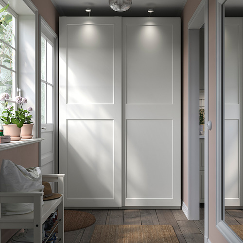 Armario blanco moderno y minimalista con puertas correderas con iluminación incorporada y decoración vegetal.