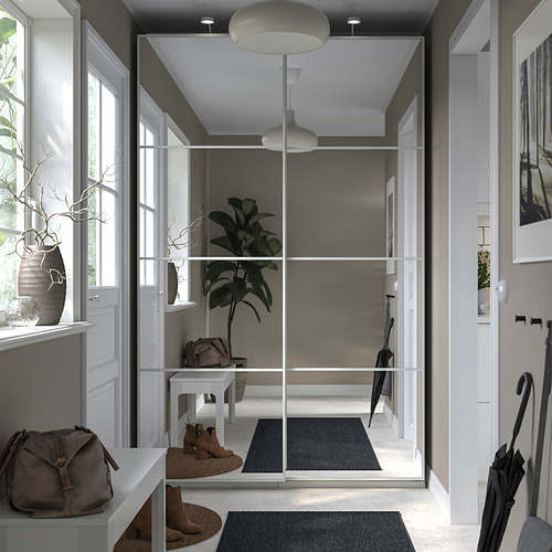 Una entrada moderna y minimalista con decoración en gris y blanco. Incluye una unidad de almacenamiento con frente de vidrio, una gran planta de interior y accesorios elegantes.