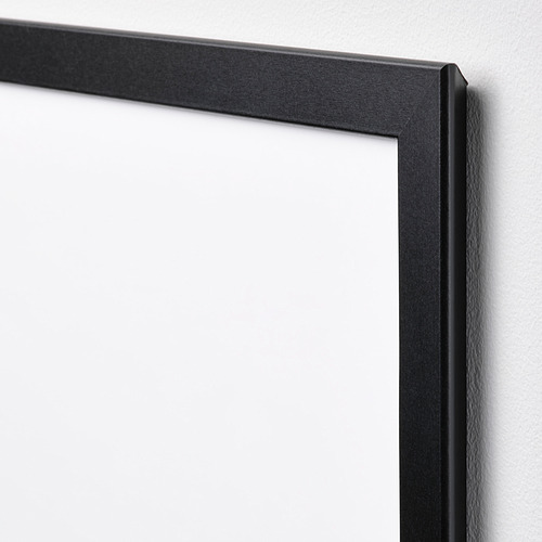 Marco de fotos negro con un diseño elegante, apoyado contra una pared blanca. Fabricado con materiales seguros, ideal para habitaciones infantiles.