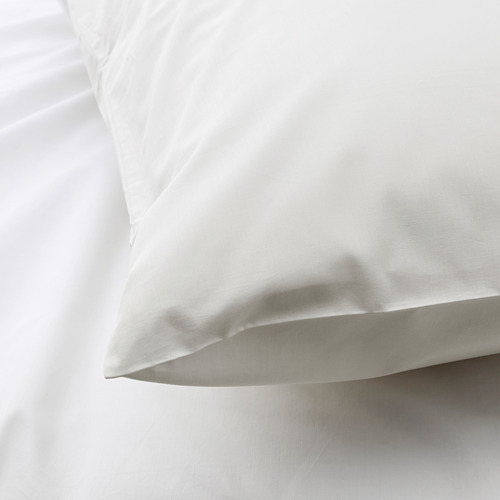 Funda de almohada blanca suave y nítida sobre una cama, con una textura de tela suave.