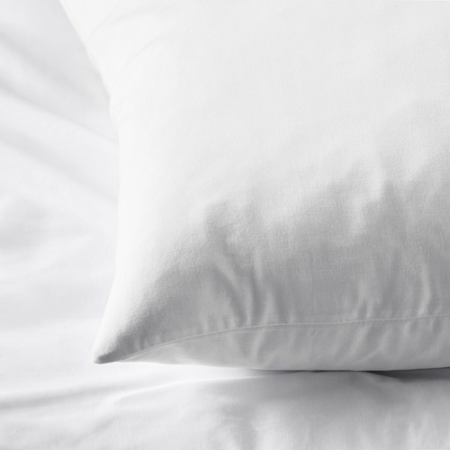 Funda de almohada blanca limpia y nítida sobre una cama, con un tejido de algodón suave y de alta calidad, que refleja suavidad y comodidad.