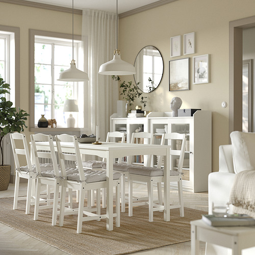 Comedor con muebles blancos, sillas VIPPÄRT, lámparas colgantes, espejo, estantería y grandes ventanales.