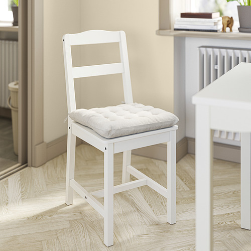 Una almohadilla de silla vippart blanca sobre una silla de madera blanca.