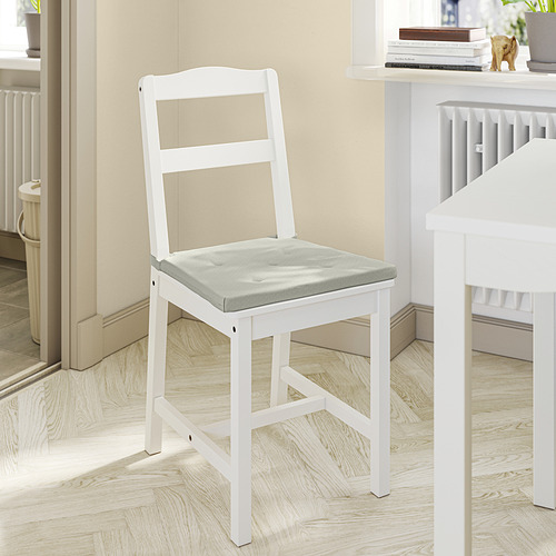 Silla de madera blanca con asiento acolchado gris, diseño sencillo, colocada en una acogedora habitación.