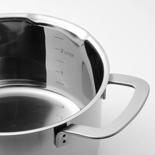 Primer plano del interior de las macetas de acero inoxidable que muestra marcas graduadas de 2l, mango ancho para agarre, superficie lisa reflectante.