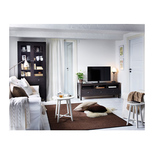 Sala de estar moderna con mesas KRAGSTA marrones, muebles blancos, tv y decoración.