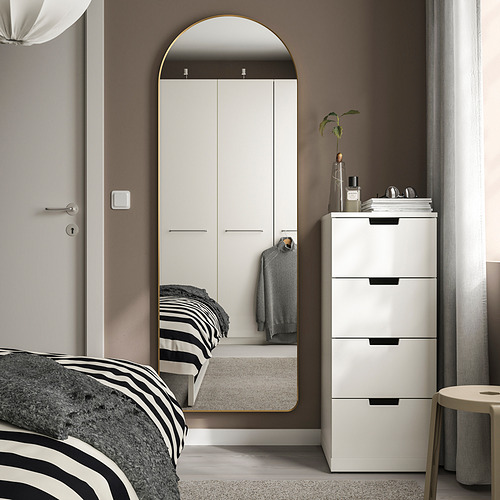 Dormitorio moderno con gran espejo LINDBYN arqueado, decoración minimalista en tonos dorados.