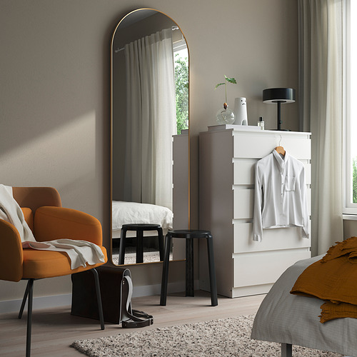 El espejo con marco dorado LINDBYN junto a la cómoda blanca complementa la decoración moderna.
