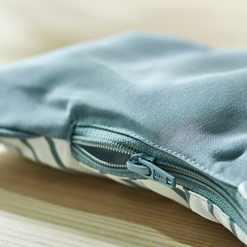 Primer plano de una cremallera gris sobre un cojín de apoyo para bebés inflable y reversible.
