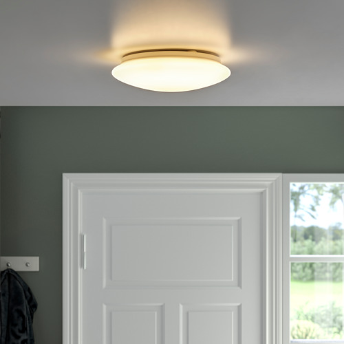 Baño moderno con lámpara de techo iluminada sobre puerta blanca para una iluminación uniforme.