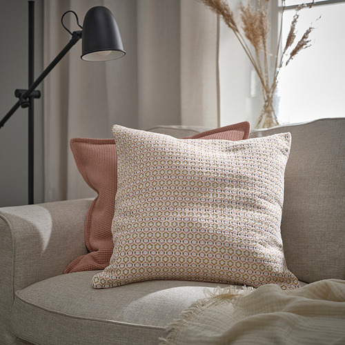 Acogedor sillón con almohada MOROTSMOTT, almohadas color melocotón, manta beige y lámpara de pie.