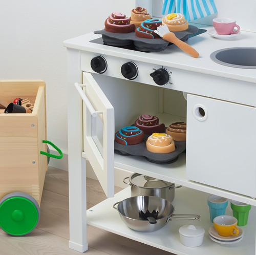 Juego de cocina de juguete con horno, ollas, tazas y comida falsa.