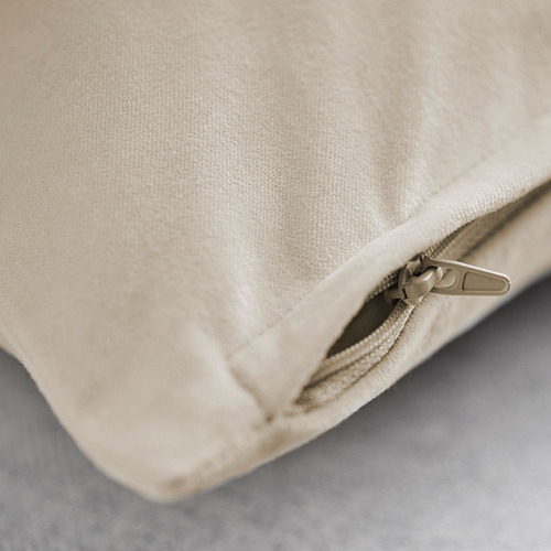 Primer plano de una funda de cojín de terciopelo de algodón beige afelpada con cremallera de calidad, que muestra su textura suave y su acabado liso.