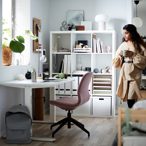 Mujer de KALLAX estantería con libros, silla, escritorio, plantas.