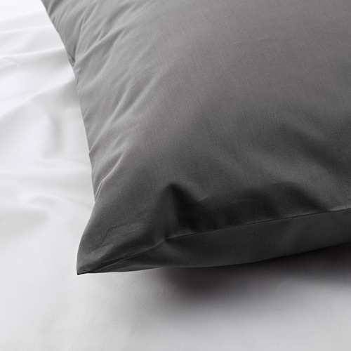 Primer plano de una funda de almohada lisa y de alta calidad en tela densa, fresca y fresca, que muestra una fina artesanía.