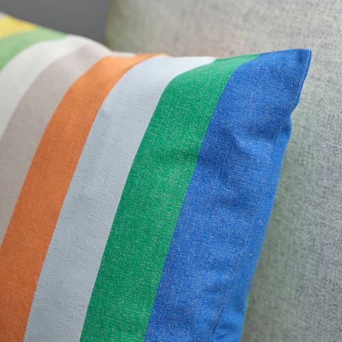 Funda de cojín a rayas vibrantes en naranja, blanco, verde y azul. Tejido duradero y suave, doblado cuidadosamente.