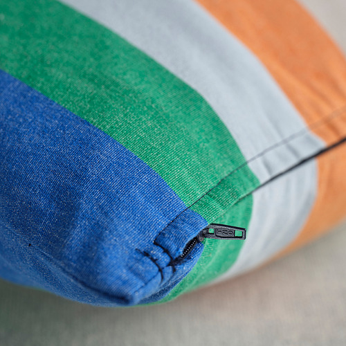 Primer plano de la funda de cojín a rayas multicolor, con detalle de cremallera. Diseño brillante y moderno con rayas azules, verdes, grises y naranjas.