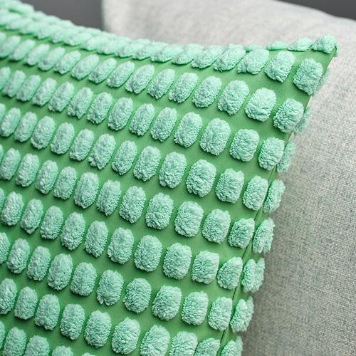 Funda de cojín verde con patrón suave y texturizado; Muestra calidad y detalle táctil.