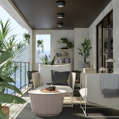 Patio moderno con sofá HAVSTEN blanco, mesa de centro redonda y varias plantas.